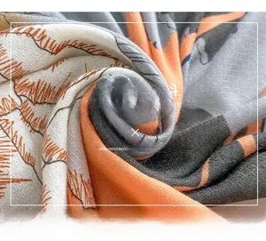 Macro detail of the woven texture and botanical print on a lightweight silk blend scarf
