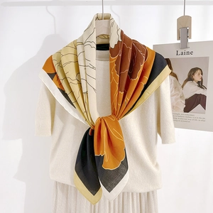 French retro oversized floral scarf in mustard and ginger tones on a chic model outfit