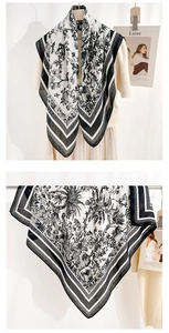 Dettaglio dell'elegante sciarpa con motivo floreale bianco e nero e bordo geometrico