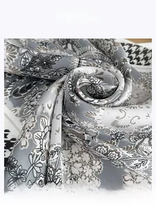 Detailed view of faux silk scarf featuring floral prints and houndstooth pattern texture