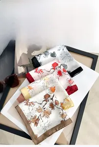 Detailed view of floral satin silk square scarves with premium hemmed edges and smooth texture