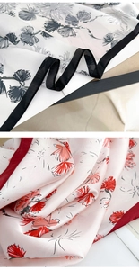 Detailed macro view of floral print silk scarves with contrasting black and red borders
