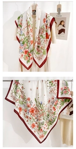 Detail showing elegant floral print silk scarf with red border and herringbone pattern