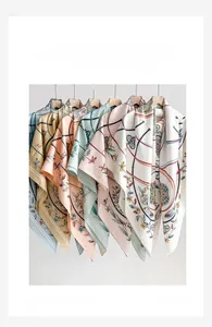 Close-up of assorted floral silk scarves with chain patterns hanging on wooden hangers