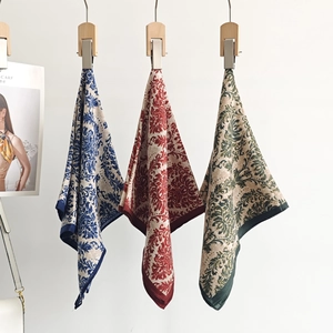 Close-up of three vintage floral square scarves in royal blue, dark red, and deep green
