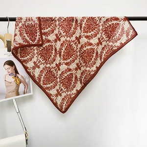 Detail of red and white damask floral pattern on a classic square silk scarf with edge stitching