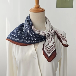 Elegant paisley pattern cotton linen small square neck scarf tied on a white shirt collar