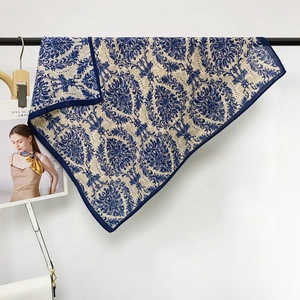 Close-up of Baroque pattern on a blue floral silk square scarf hanging on a metal rod