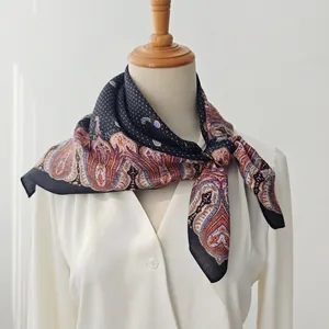Black paisley square silk scarf styled on a white shirt with colorful vintage patterns