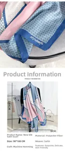 Detailed close-up of silk-textured long scarf with pink and blue geometric houndstooth pattern