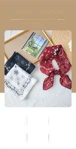 Close-up of vintage scalloped edge square scarves with elegant paisley and floral patterns