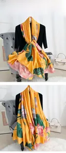 Gros plan détaillé de l'écharpe en soie jaune avec lotus rose élégant et motif de feuilles
