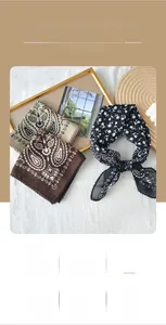 Detailed view of paisley silk scarves with delicate scalloped edges and refined prints