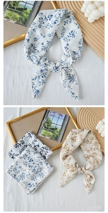 Detail of floral printed neckerchief with delicate lace crochet trim on soft cotton fabric