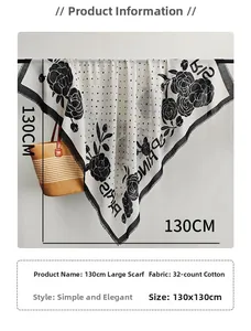 Detail of white scarf with black floral prints and fringe edges beside woven basket