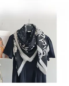 Detail of mercerized wool scarf with black and white floral polka dot print and frayed edges