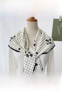 Close-up of cream polka dot and floral print triangle scarf tied on a white mannequin