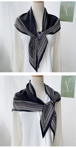 Detail of black and white geometric pattern satin triangle scarf tied on a white shirt