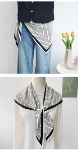Detail view of monochrome geometric print silk scarf worn as a stylish waist belt and necktie