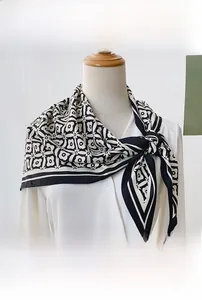 Detail of floral geometric pattern on a lightweight satin neck scarf tied over a shirt