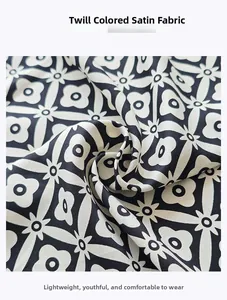 Detail of twill satin fabric showing black and white floral geometric print patterns