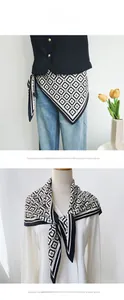 Detail showing the black and white geometric silk scarf worn as a waist belt and necktie