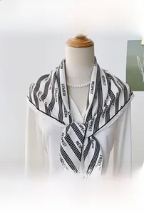 Detailed view of lightweight silk-like triangle scarf featuring black stripes and RESPECT print
