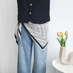 Fashionable black and white geometric stripe silk scarf worn as a stylish waist belt