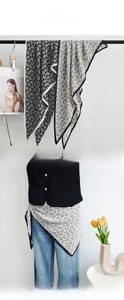 Versatile black and white floral triangle scarf styled on an outfit and hanger