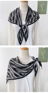 Close-up of black and white satin scarf with RESPECT print styled on a white shirt