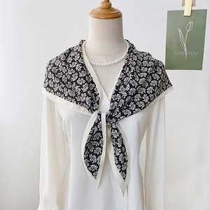 Elegant black and white paisley silk triangle scarf worn as a stylish shawl wrap