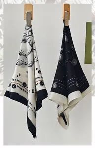 Detail view of herringbone silk square scarves with floral and dot patterns on hangers