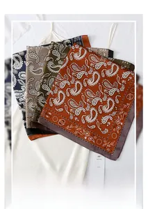 Detail view of four paisley silk scarves in navy, beige, green, and orange colors