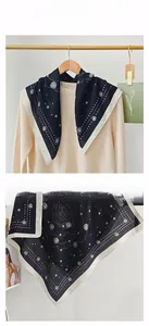 Detail of a vintage black square scarf with white floral patterns and polka dot border