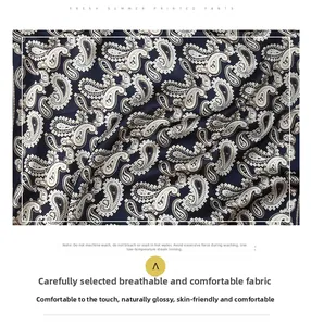 Detailed macro view of dark blue paisley silk fabric with smooth satin texture and shine