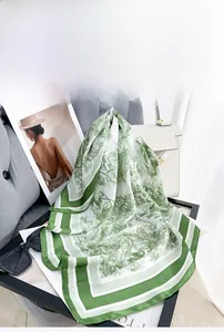 Detail of white and green Toile de Jouy floral print scarf with silk-like texture