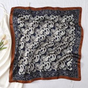 Detail of vintage paisley silk scarf with brown satin border and navy blue floral print