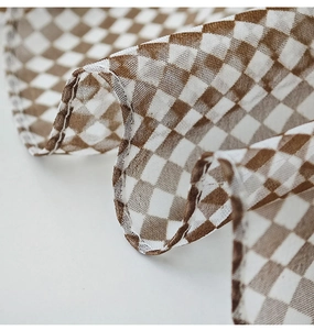 Macro detail of elegant brown and white checkered chiffon scarf with fine stitched edges