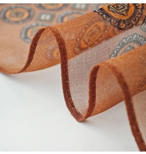 Dettaglio ravvicinato della stampa geometrica vintage e della trama in chiffon dello scialle