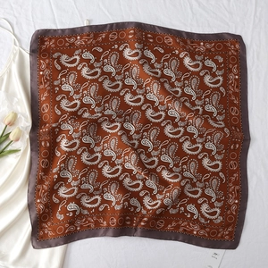Detail of red paisley silk scarf with vintage floral patterns on white satin background