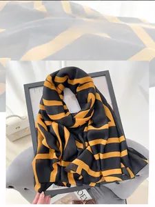 Close-up of black and yellow striped cotton linen scarf layered on decorative props