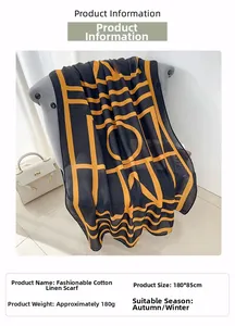 Detail of black cotton linen scarf with orange letters draped on a sofa, size 180x85cm