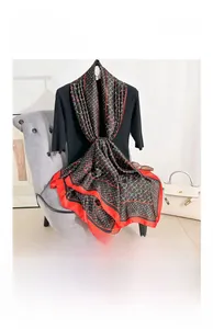 Gros plan d'un foulard en satin de soie avec motifs de chaînes rouge et or