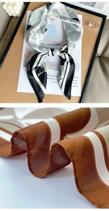 Gros plan sur le tissu léger du foulard en soie à fleurs et les rayures marron détaillées