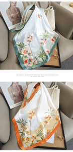 Detail view of floral print silk scarves in mint green and orange on a chic leather sofa