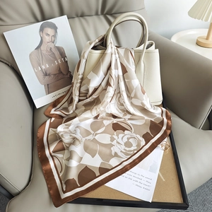 Élégant foulard en soie à fleurs aux tons terre drapé sur un sac à main chic
