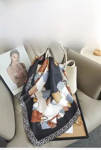 Close-up of imitation silk scarf with leopard and handbag print on a leather bag