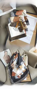 Detail of silk-feel scarf featuring vintage leopard print and handbag motifs styled on a bag