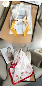Vue détaillée de foulards en soie synthétique légère avec imprimés floraux jaunes et roses