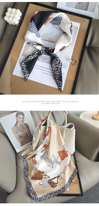 Detail of silk scarf with leopard print and polka dots tied to a beige leather handbag